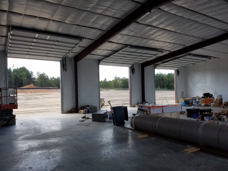 Commercial follow-the-roof-pitch overhead door installed by Partridge Door