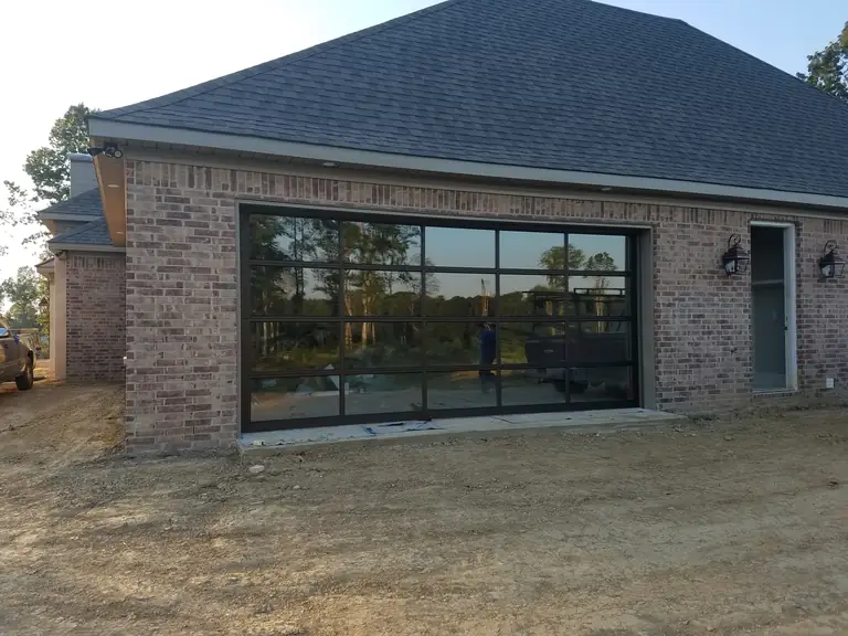 Brick home with a full-view glass garage door